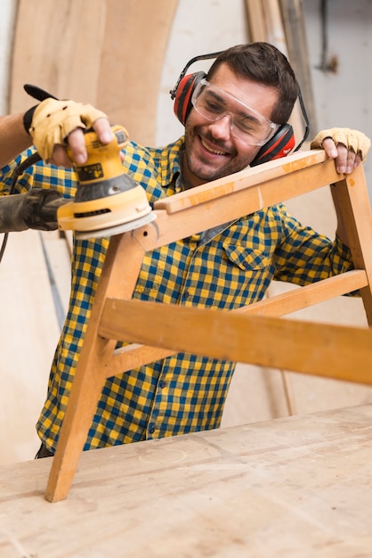 carpintero macho sonriente ablandando bordes muebles madera lijadora 23 2147944856