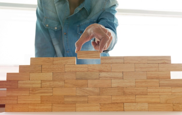mujer camisa pantalones vaqueros sosteniendo bloques madera juego construccion pequena pared ladrillo concepto riesgo 1715 411